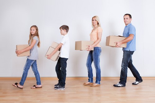Professional movers handling household items and protective packing materials